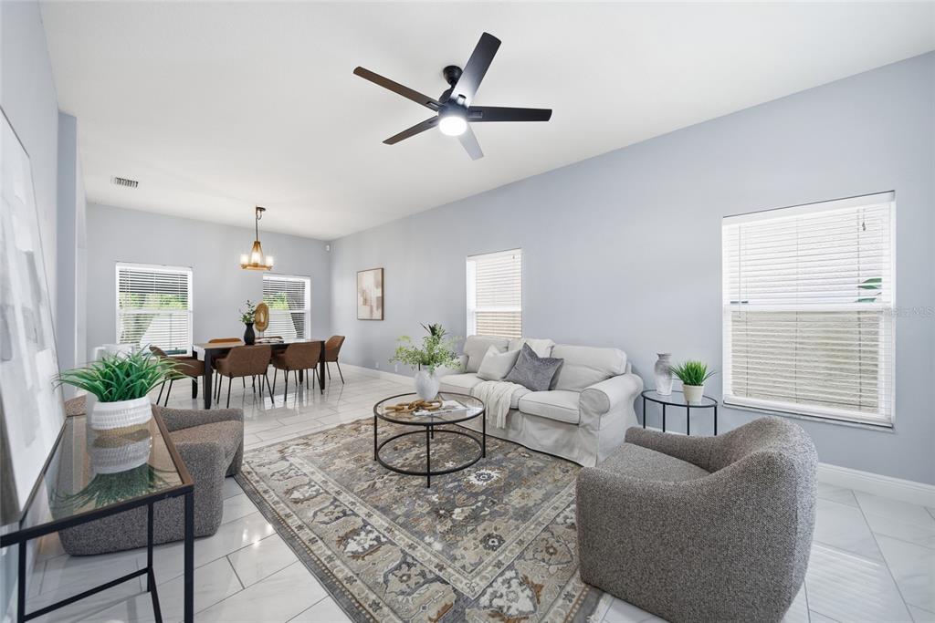 A living and dining room area with light blue walls, tile floors, and a ceiling fan — 7749 75TH STREET N, PINELLAS PARK, FL