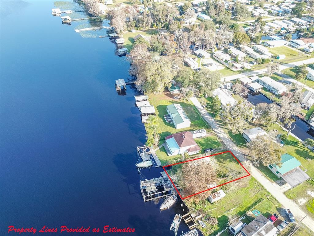 An aerial view shows a waterfront lot outlined in red with a private boat dock — 144 MAGNOLIA TRAIL, SATSUMA, FL