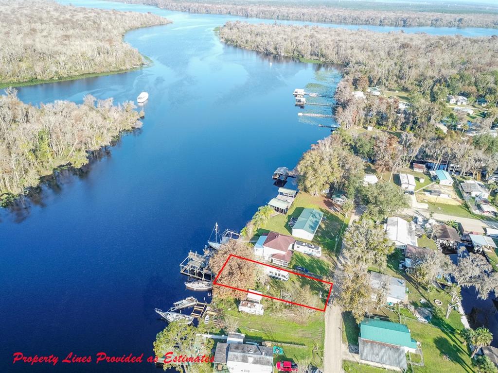 An aerial view shows a waterfront property outlined in red along a riverbank — 144 MAGNOLIA TRAIL, SATSUMA, FL