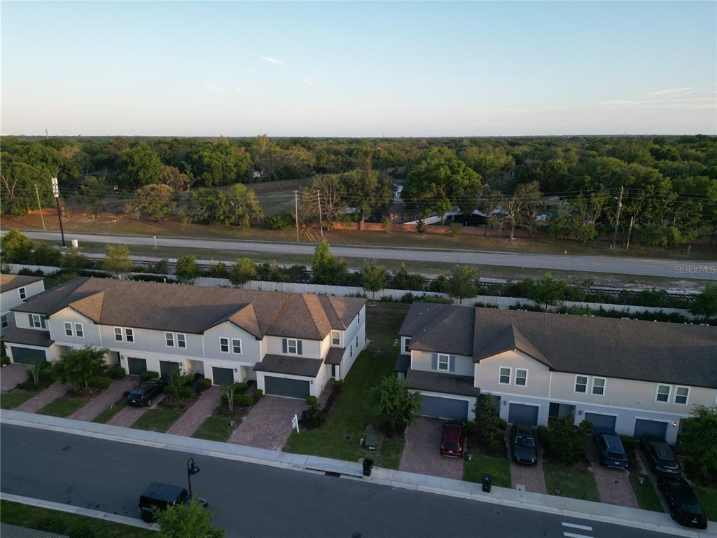 An aerial view shows two rows of townhouses with attached garages and driveways — 2063 HAREBELL LANE, OCOEE, FL