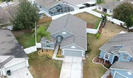 An aerial view shows a suburban house with a gray roof and a concrete driveway — 6414 OPEN PASTURE COURT, WESLEY CHAPEL, FL