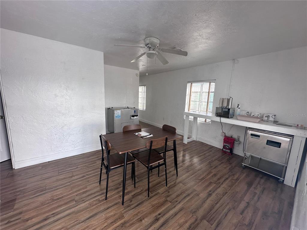 A dining area features wood-look flooring, a ceiling fan, and a kitchenette with stainless appliances — 3000 KENILWORTH BOULEVARD, SEBRING, FL