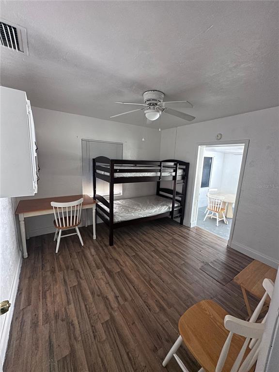A bedroom features wood-look flooring, a dark wood bunk bed, a desk, and a ceiling fan — 3000 KENILWORTH BOULEVARD, SEBRING, FL