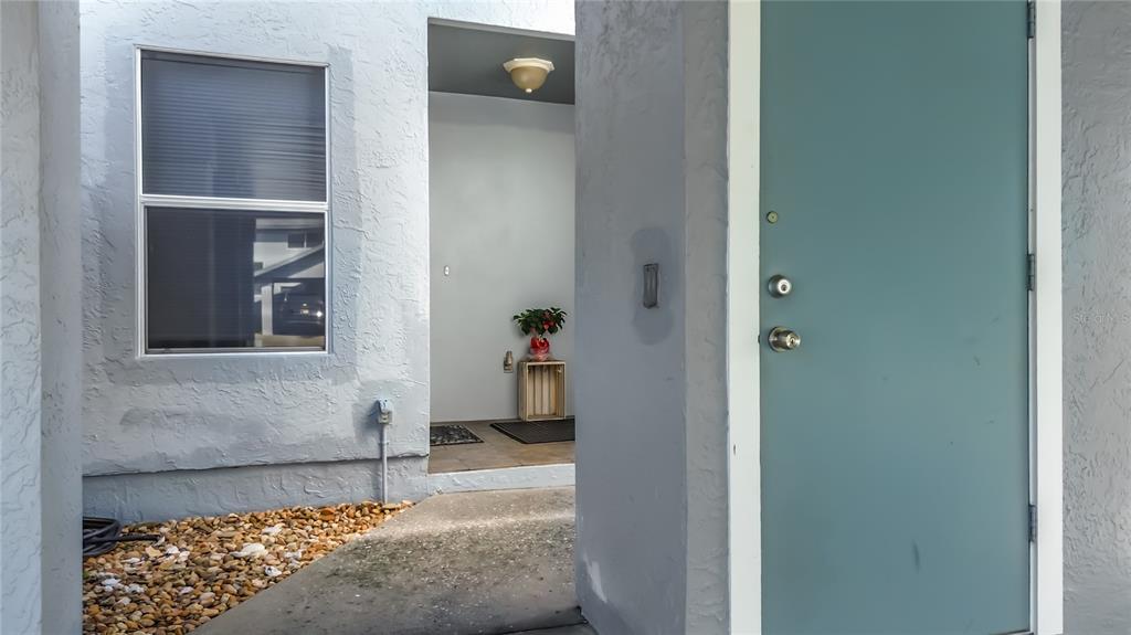 A light blue exterior wall features a window and a door leading to a covered entryway — 11025 W HARBOR WATCH LOOP UNIT 31, CRYSTAL RIVER, FL