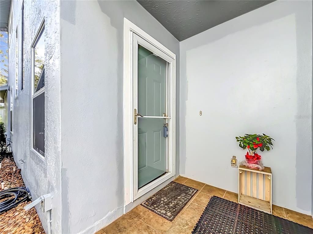 A light blue exterior entryway features a storm door, tiled floor, and a potted plant — 11025 W HARBOR WATCH LOOP UNIT 31, CRYSTAL RIVER, FL