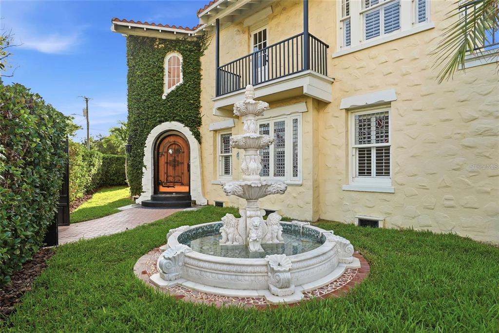 A tiered stone fountain sits in the front yard of a yellow stucco house — 190 BOSPHOROUS AVENUE, TAMPA, FL