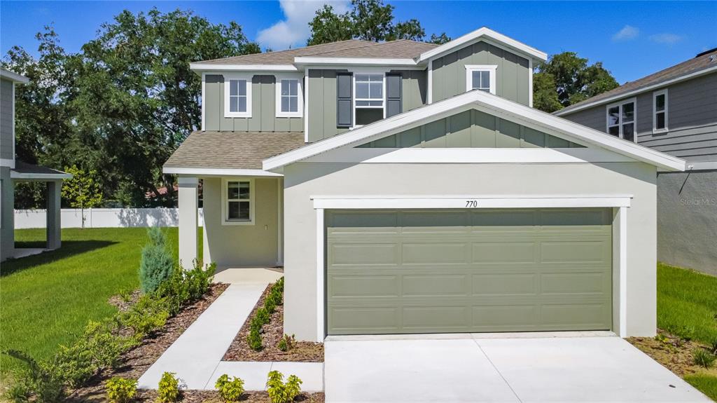 A white front door with a smart lock stands next to carpeted stairs and wood-look flooring — 770 LAKE DELL AVENUE, DUNDEE, FL