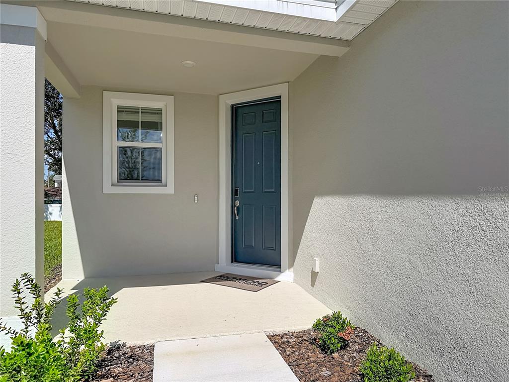 An entryway features wood-look tile flooring, a white front door, and carpeted stairs — 770 LAKE DELL AVENUE, DUNDEE, FL