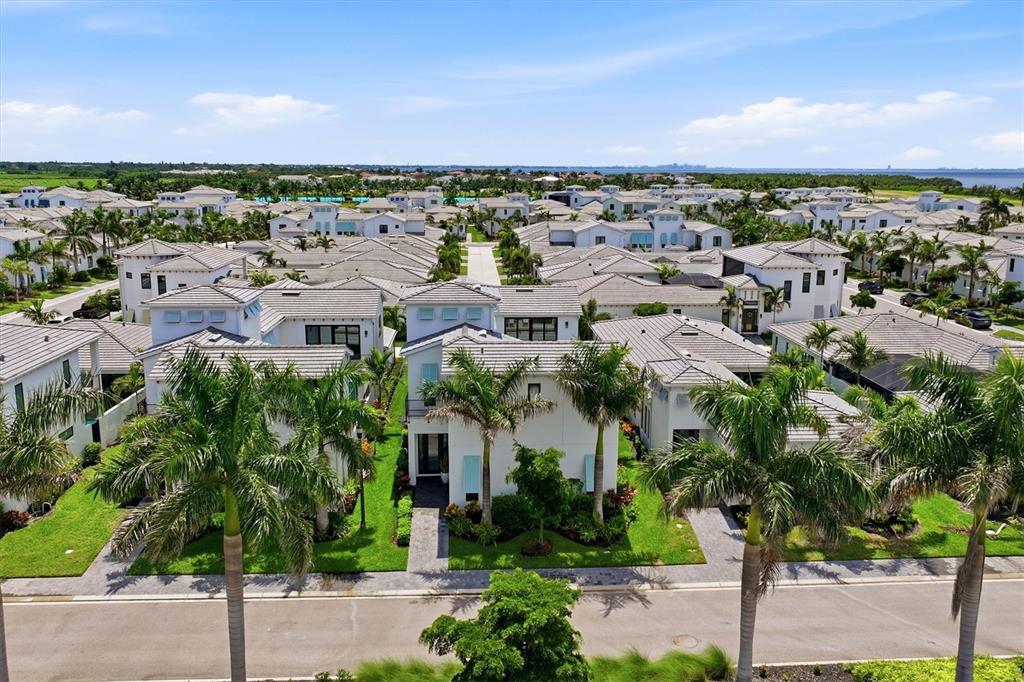 An aerial view shows a residential neighborhood with white houses, palm trees, and paved streets — 5935 REDBAY BOULEVARD, BRADENTON, FL