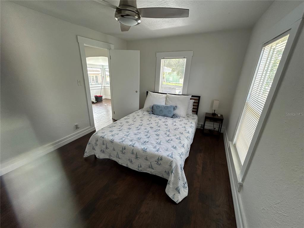 A bedroom with dark wood flooring, a ceiling fan, and a bed with patterned bedding — 2321 TRELAIN DRIVE S, ST PETERSBURG, FL