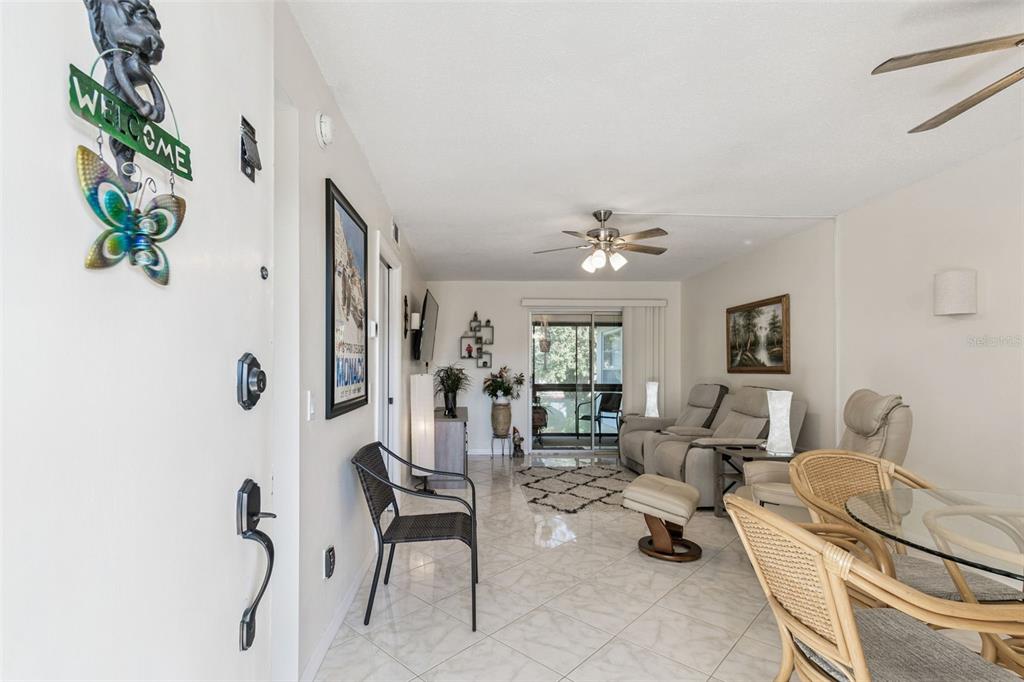 A living room features tile flooring, a ceiling fan, and a sliding glass door — 2750 E BAY DRIVE UNIT 12B, LARGO, FL