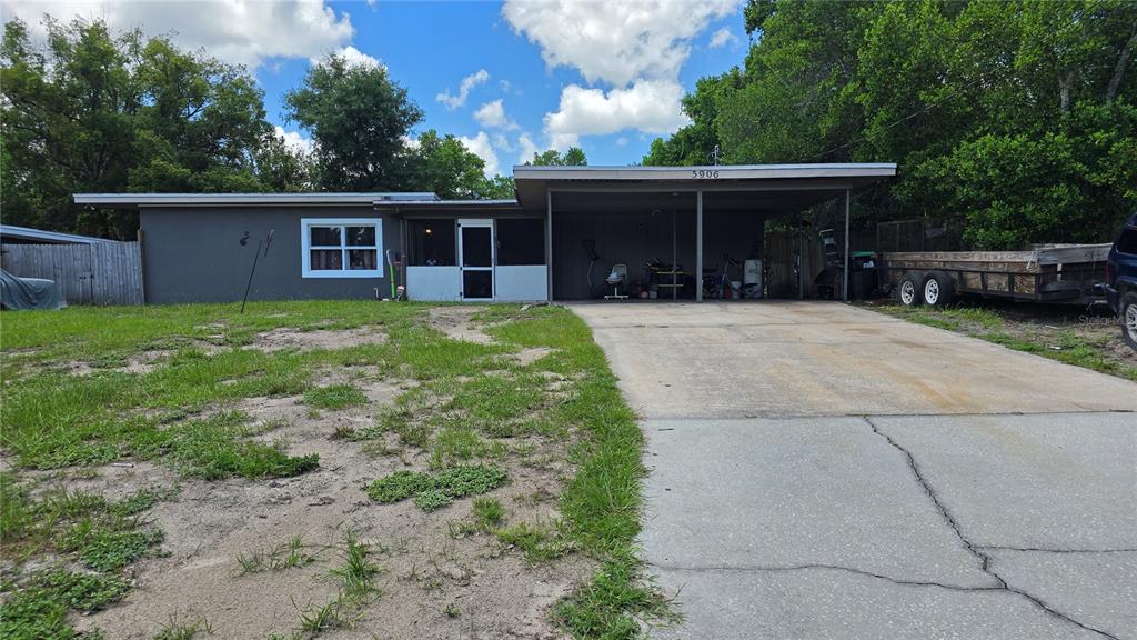 A single-story house with a flat roof, a carport, and a patchy grass front yard — 5906 JUDY DEE DRIVE, ORLANDO, FL