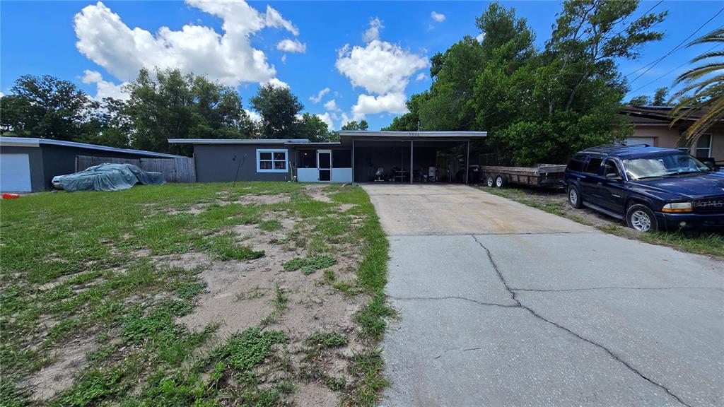 A single-story house with a carport, a concrete driveway, and a large, grassy front yard — 5906 JUDY DEE DRIVE, ORLANDO, FL
