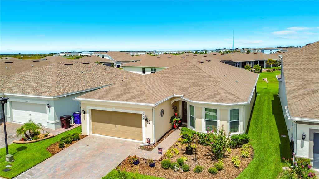 An aerial view of a single-story suburban house with a tan exterior and brown roof — 1974 SPRING SHOWER CIRCLE, KISSIMMEE, FL