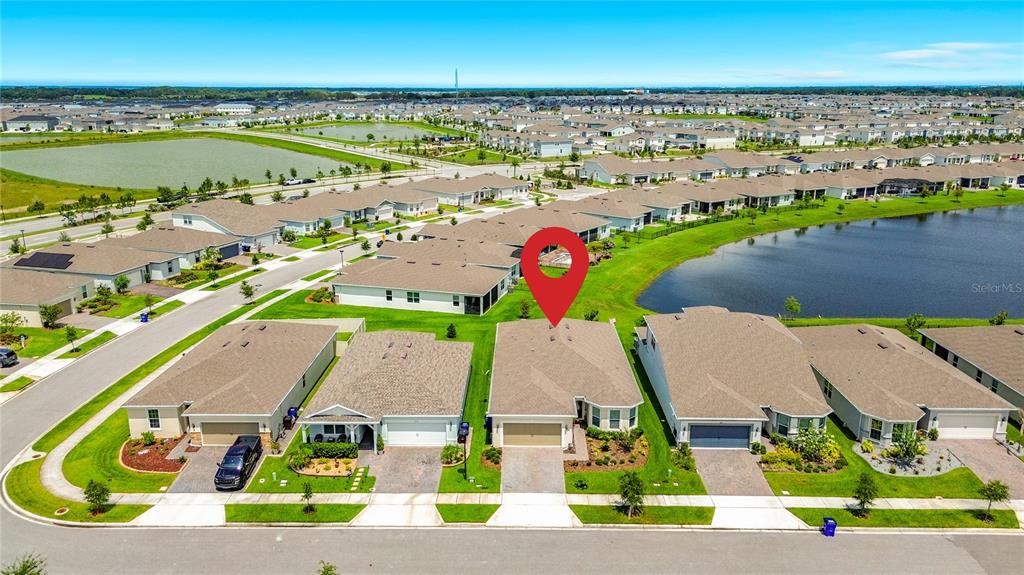 An aerial view shows a suburban residential neighborhood with a red pin marking a house — 1974 SPRING SHOWER CIRCLE, KISSIMMEE, FL