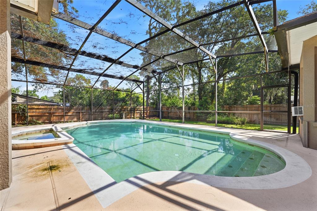 A screened-in swimming pool and spa area with a concrete deck and wooden privacy fence — 1200 ALBERTA STREET, LONGWOOD, FL