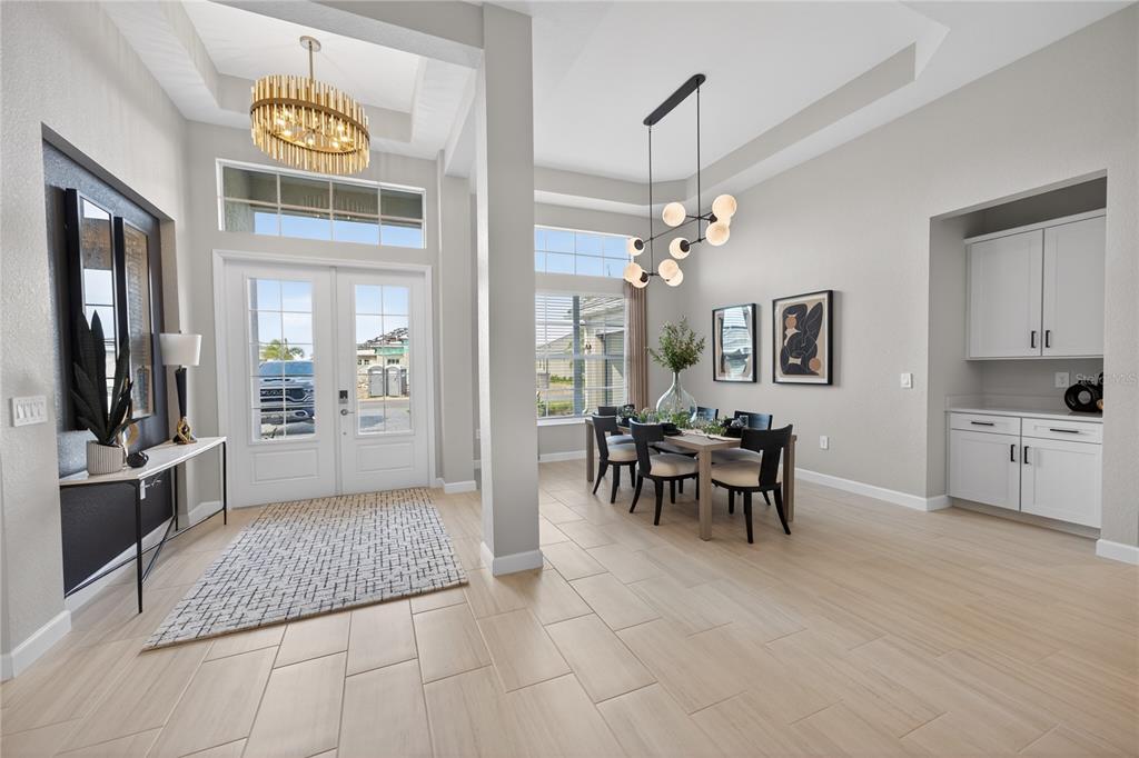 A bright dining area and entryway feature light tile floors, modern light fixtures, and white cabinetry — 18731 CHERRYSTONE WAY, BRADENTON, FL