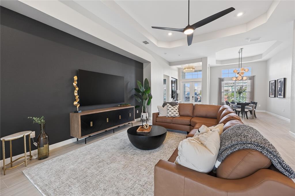 A living room features a dark accent wall, leather sectional, and open dining area — 18731 CHERRYSTONE WAY, BRADENTON, FL