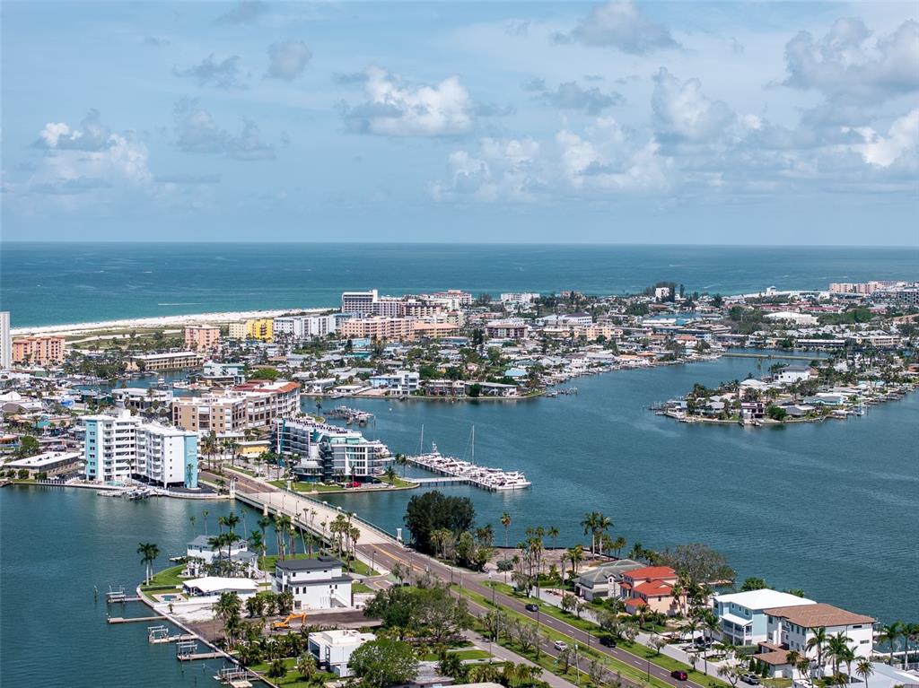 An aerial view shows a bridge connecting a coastal area with boats and buildings — 2 PARADISE LANE, TREASURE ISLAND, FL