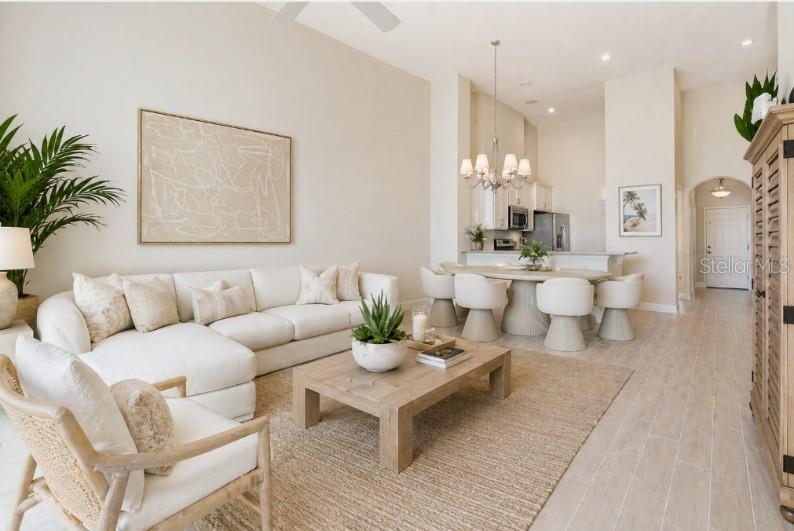 A bright, open-concept living and dining area features neutral furnishings, light wood flooring, and high ceilings — 15 OCEAN CREST WAY UNIT 1342, PALM COAST, FL