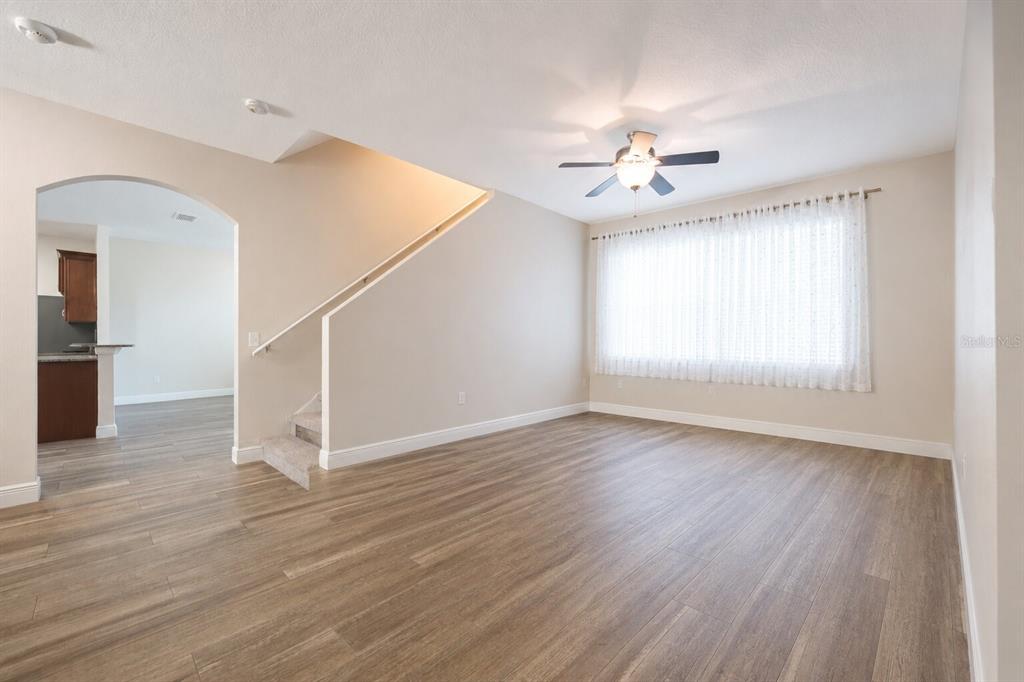 A living room with wood-look flooring, a ceiling fan, and a staircase with a railing — 1147 DEGRAW DRIVE, APOPKA, FL