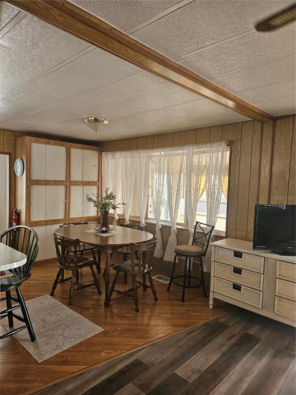 A dining area features wood-paneled walls, a round wooden table, and a mix of chairs — 5670 TEAHOUSE ROAD, VENICE, FL