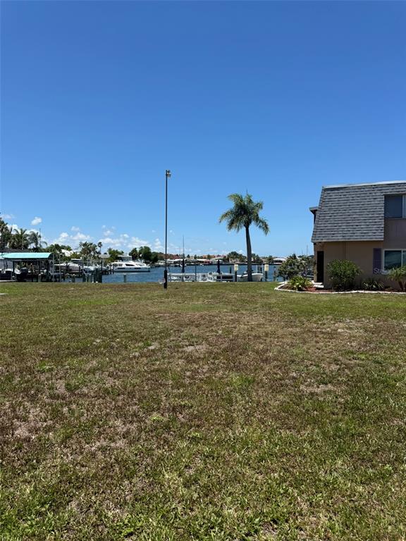 A grassy lot overlooks a canal with docked boats and a nearby residential building — 1000 APOLLO BEACH BOULEVARD UNIT 204, APOLLO BEACH, FL