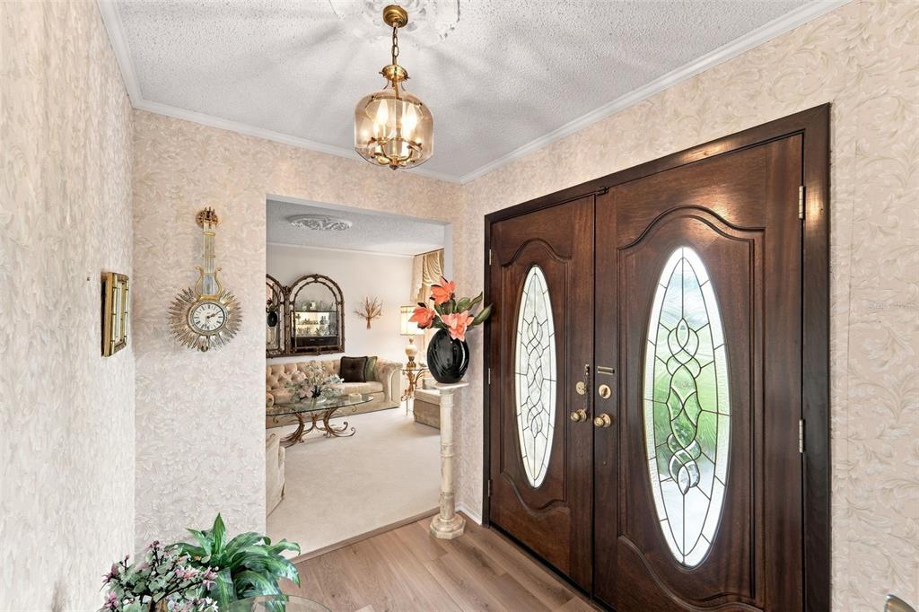 A foyer features a dark wood double door with oval glass inserts and a pedestal vase — 14 MADEIRA AVENUE, ORLANDO, FL