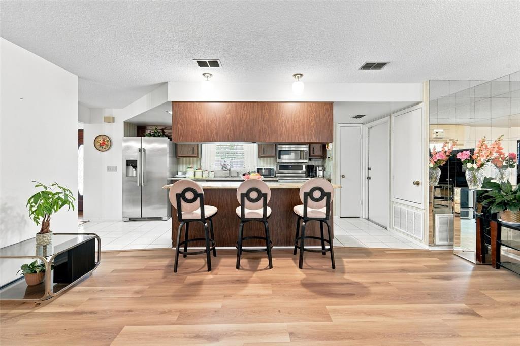 A kitchen features dark wood cabinets, granite countertops, stainless steel appliances, and a breakfast bar — 14 MADEIRA AVENUE, ORLANDO, FL