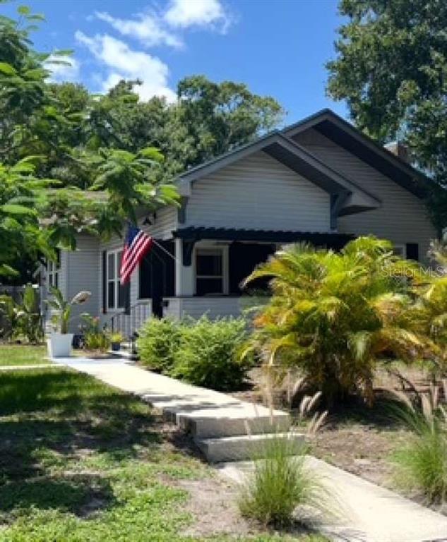 A single-story house with light siding, a dark porch, and a concrete walkway in front — 2802 4TH AVENUE W, BRADENTON, FL