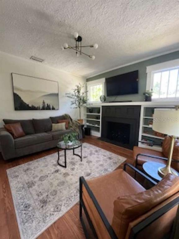 A living room features a gray sofa, two leather armchairs, and a black fireplace — 2802 4TH AVENUE W, BRADENTON, FL