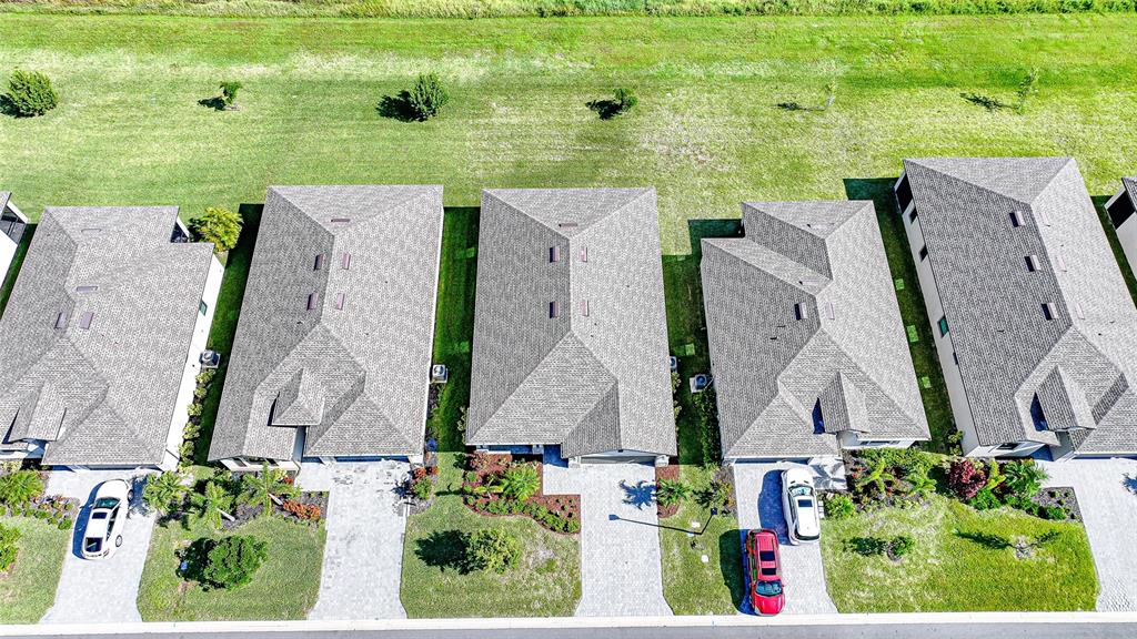 An aerial view shows a row of suburban houses with gray roofs and paved driveways — 1608 SADDLEWOOD CIRCLE, PORT CHARLOTTE, FL