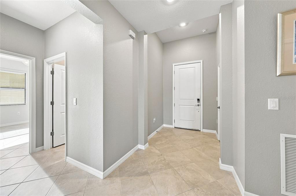 An entryway with light tile flooring, gray walls, and a white front door — 1608 SADDLEWOOD CIRCLE, PORT CHARLOTTE, FL