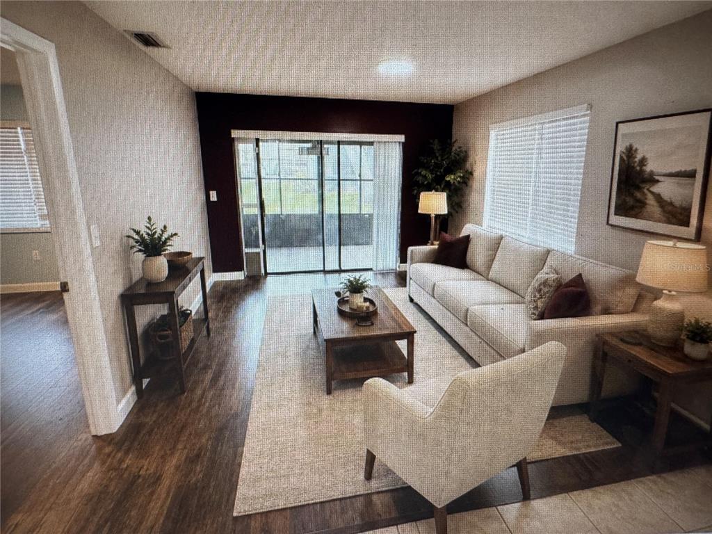 A covered balcony with a wooden railing and a sliding glass door labeled B — 511 LONGFELLOW COURT UNIT B, SAFETY HARBOR, FL
