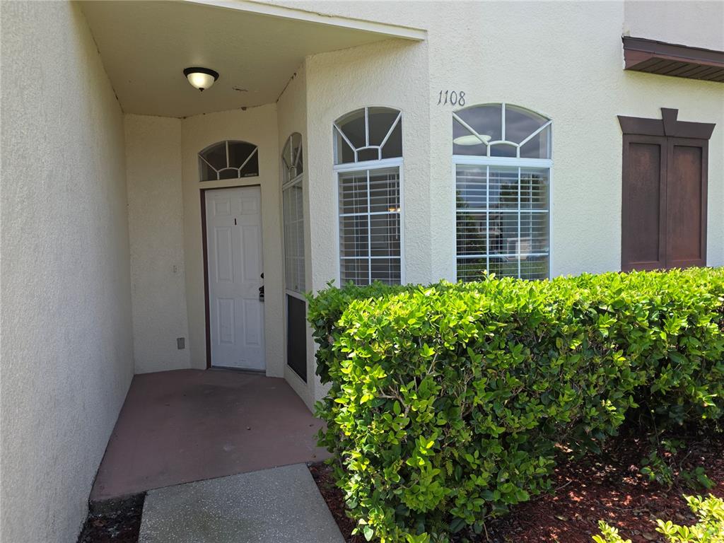 A white front door with a number one is recessed under a covered entryway — 600 NORTHERN WAY UNIT 1108, WINTER SPRINGS, FL