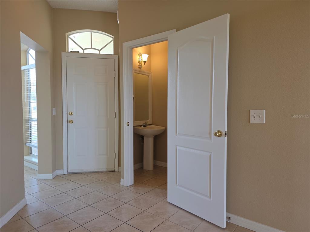 A tiled entryway features a front door with a transom window and an adjacent powder room — 600 NORTHERN WAY UNIT 1108, WINTER SPRINGS, FL