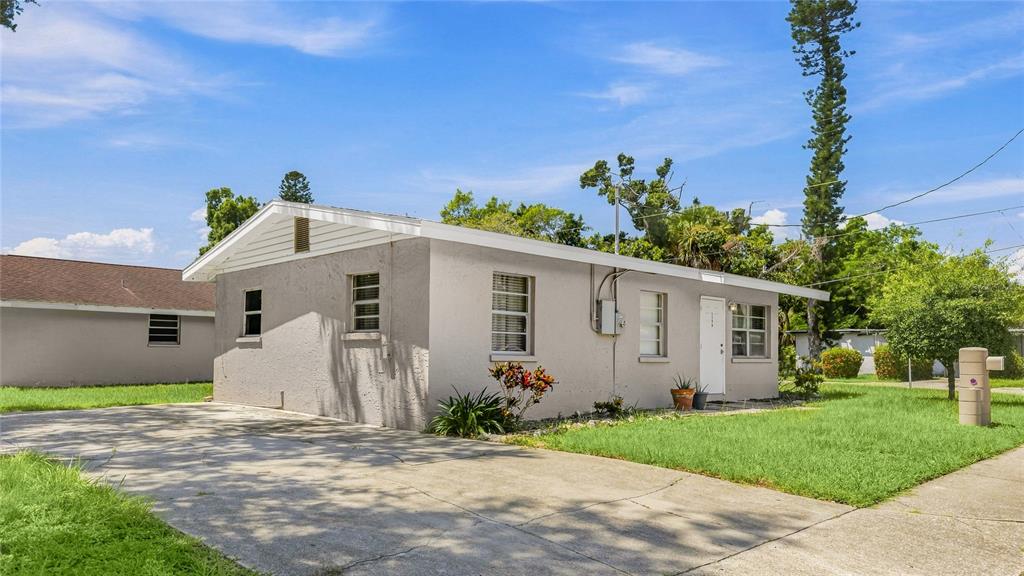 A single-story house with a concrete driveway, gray stucco exterior, and a grassy front yard — 1598 29TH STREET, SARASOTA, FL