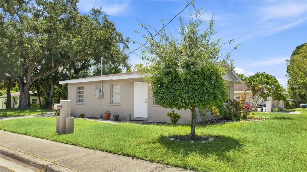 A single-story house with a beige exterior, a white front door, and a small front yard — 1598 29TH STREET, SARASOTA, FL