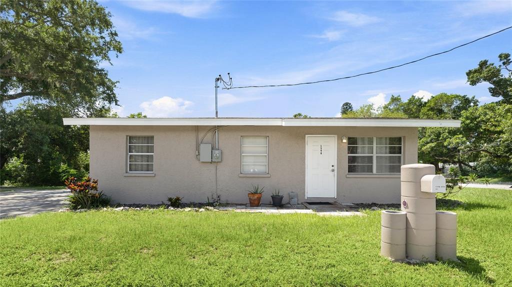 A single-story house with a flat roof, beige stucco exterior, and a front-facing mailbox — 1598 29TH STREET, SARASOTA, FL