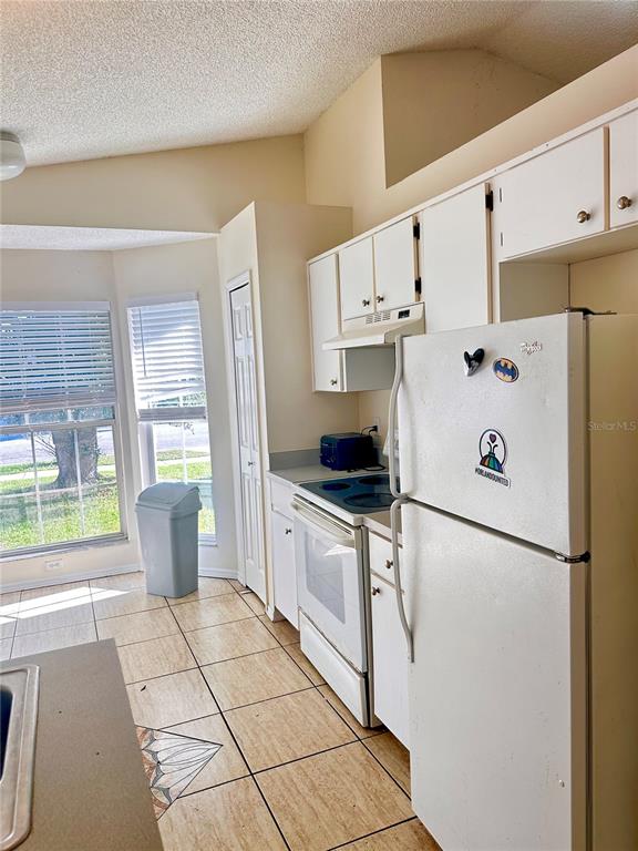 A small, empty room features beige walls, light-colored floor tiles, and a ceiling fan — 13706 GLASSER AVENUE, ORLANDO, FL