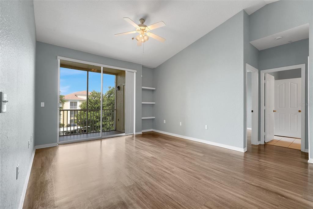 An empty room with light blue walls, wood-look flooring, a ceiling fan, and a balcony — 1150 LAKE SHADOW CIRCLE UNIT 3305, MAITLAND, FL