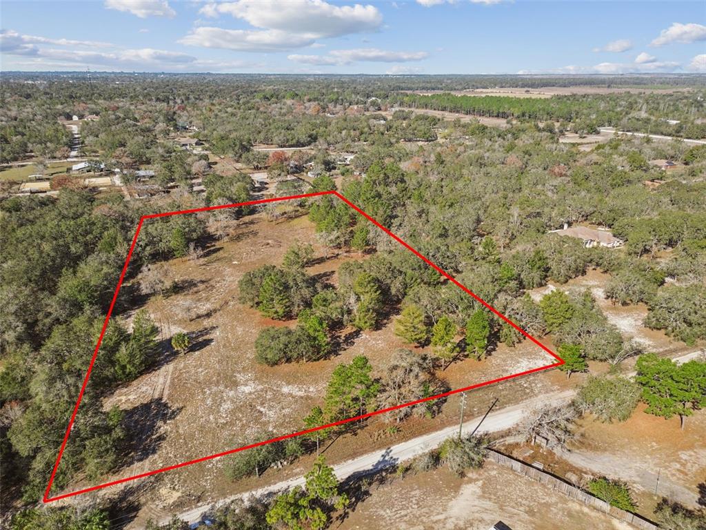 An aerial view shows a large, partially wooded plot of land outlined in red — 14459 COYOTE ROAD, HUDSON, FL