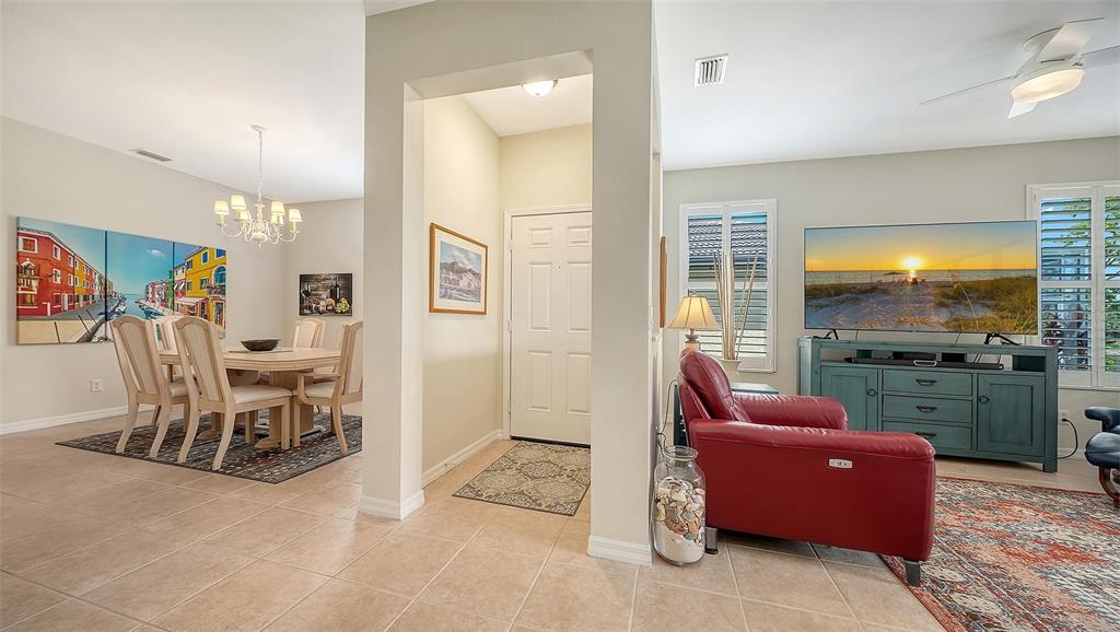 A view from a tiled entryway looking into a dining area and a living room — 1383 MASENO DRIVE, VENICE, FL