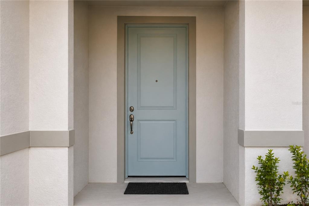 A multi-unit residential building with light-colored siding, multiple garage doors, and a shingled roof — 4899 WINDING RIVER ROAD, ORLANDO, FL
