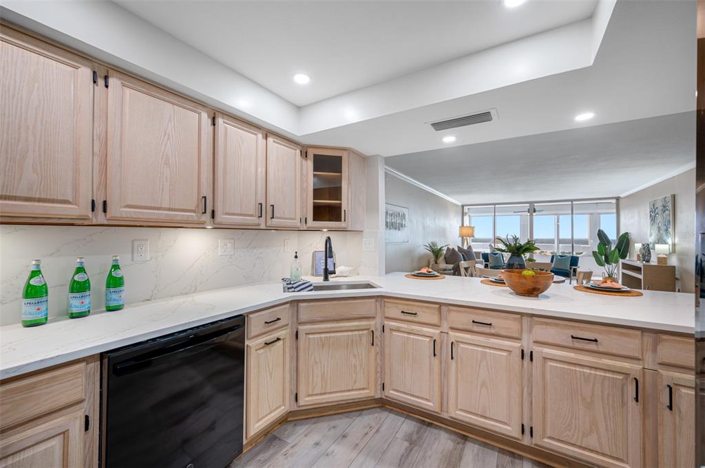 A kitchen with light wood cabinets, white countertops, and a black dishwasher — 17920 GULF BOULEVARD UNIT 2008, REDINGTON SHORES, FL