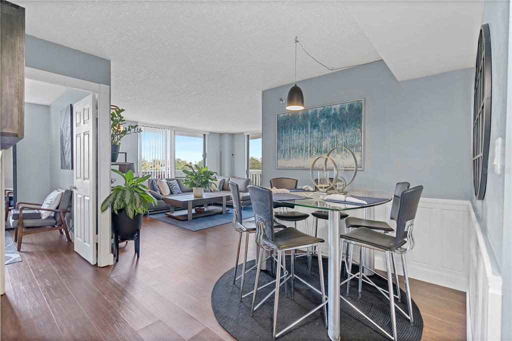 A dining area with a glass table and chairs opens into a living room with balcony — 400 E COLONIAL DRIVE UNIT 207, ORLANDO, FL