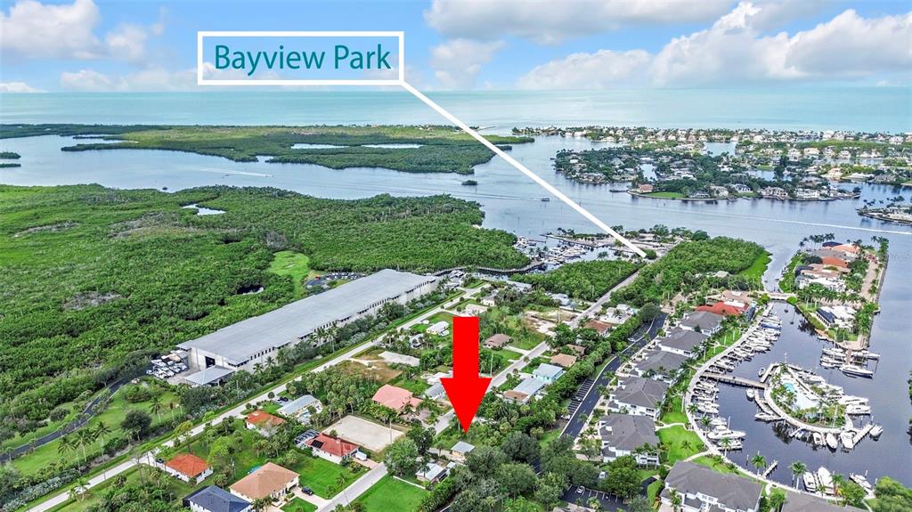 An aerial view shows a residential property marked by a red arrow near a waterway — 1931 DANFORD STREET, NAPLES, FL
