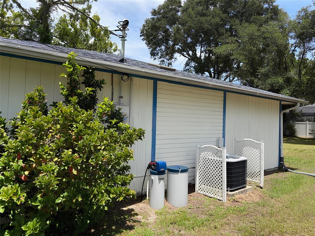 The exterior of a house features a water softener system and an air conditioning unit — 20 WOODBURY DRIVE, PALM COAST, FL
