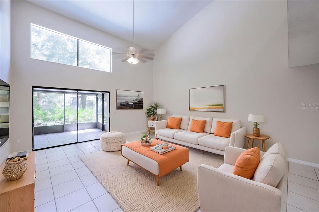 A living room with high ceilings, tile floors, a white sofa, and an orange ottoman — 499 CLUB DRIVE, WINTER SPRINGS, FL