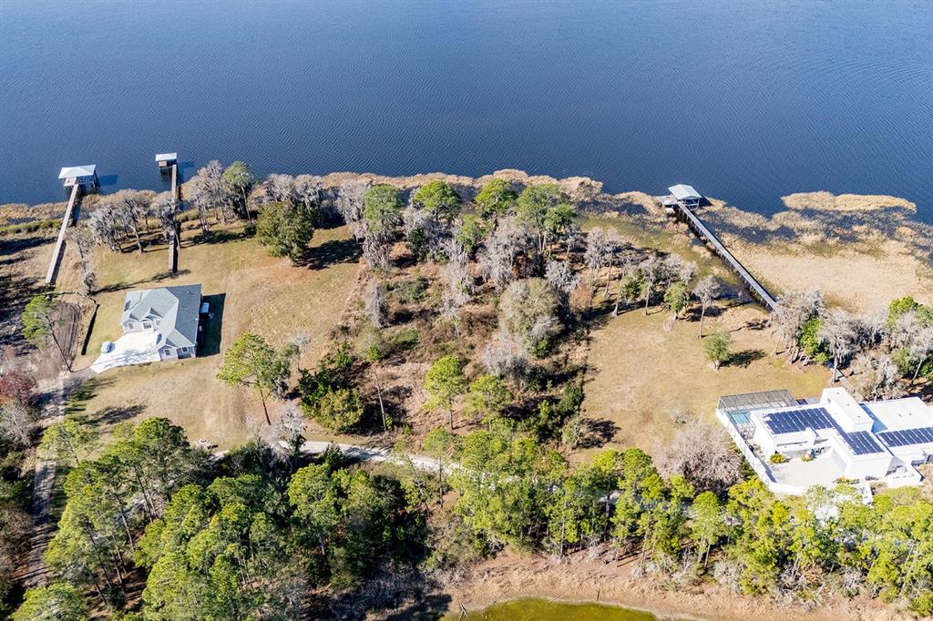 An aerial view shows two houses with private docks on a large, wooded waterfront lot — LAKESHORE DRIVE, STARKE, FL